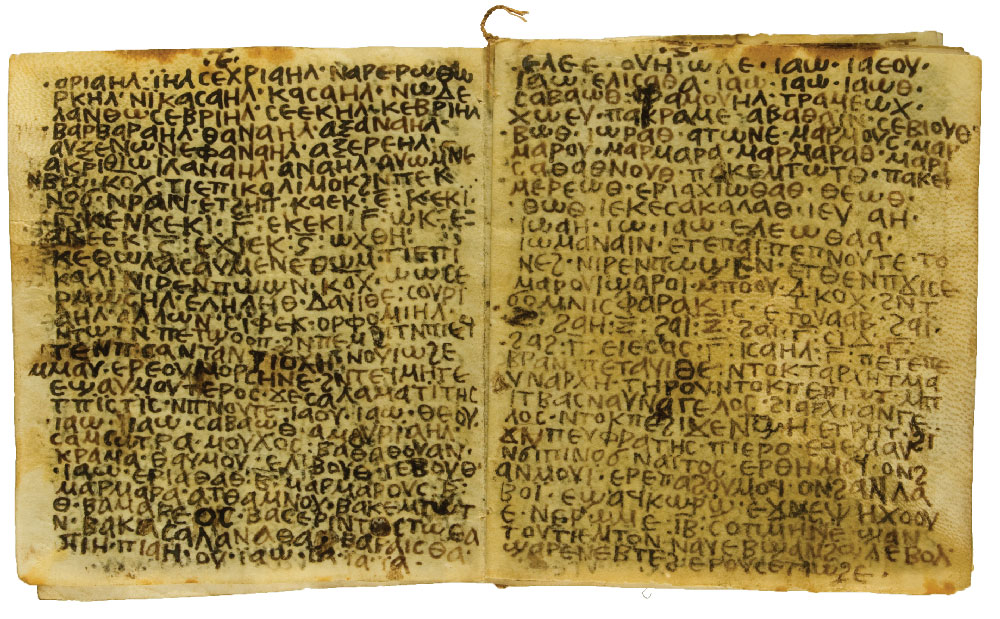 An open book on parchment written in Coptic. The pages are somewhat dark and stained.
