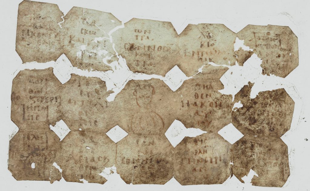 An image of a damaged sheet of parchment, folded three times vertically and five times horizontally.. Each of the sections created by the folds has a short Greek text written in it, except the central square, which has a human torso drawn. The spaces between the sections have been cut to produce diamond shapes.