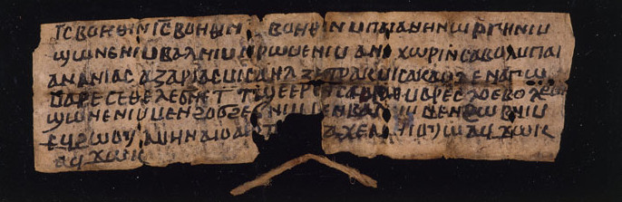 An image of a long strip of paper, folded several times, with 6 lines of Coptic written on it.