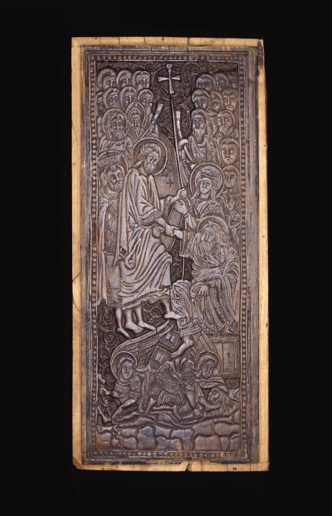 An image of a tall wooden panel. In the centre, Jesus is shown holding a staff topped with a cross, lifting an old man with a halo out of a trapdoor. Behind him are many other haloed figures. At the bottom, two winged angels are trampling on an emaciated humanoid figure.
